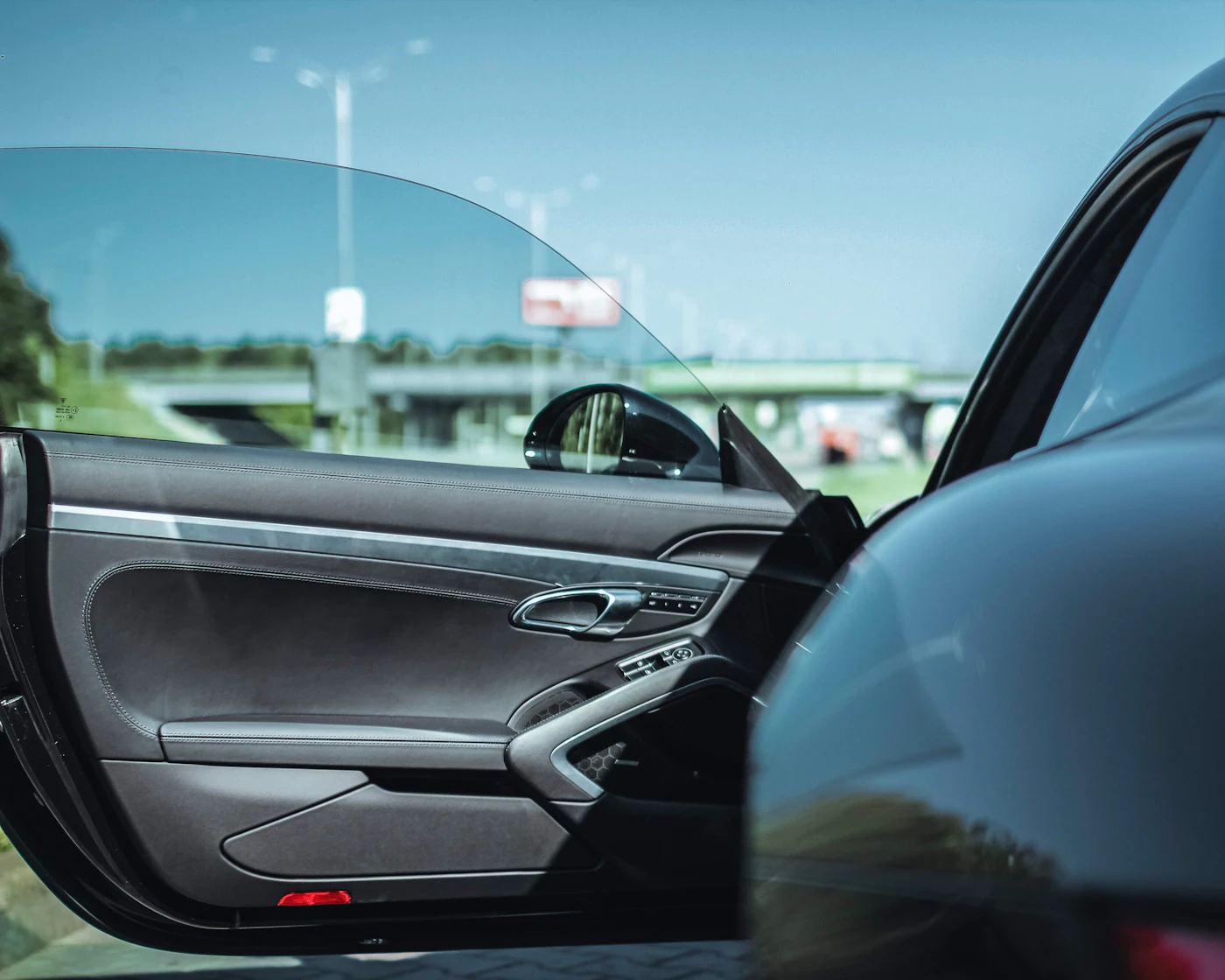 Dark tinted car window on a black vehicle, illustrating Michigan tint laws